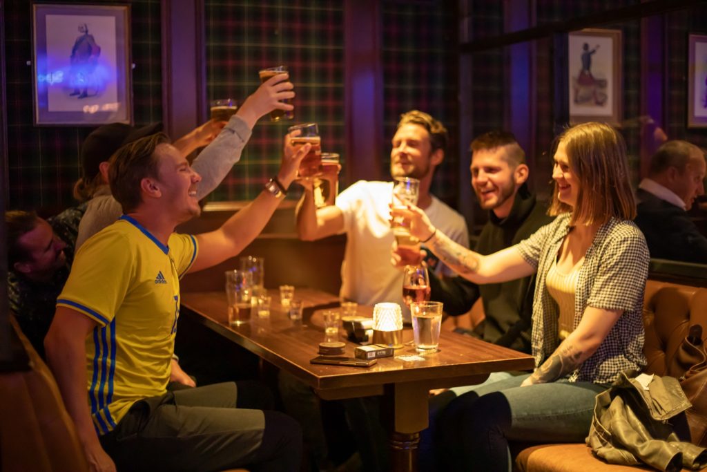 Bilde av glade mennesker som skåler på The Scotsman