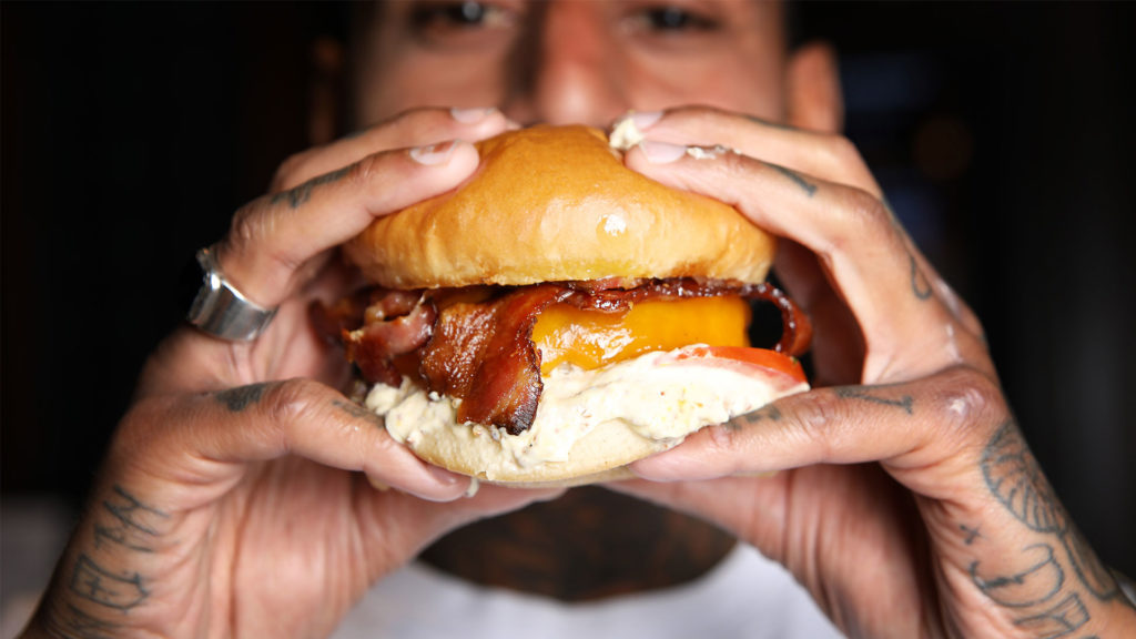 Bilde av en kokk som holder en deilig burger med hendene på The Scotsman.