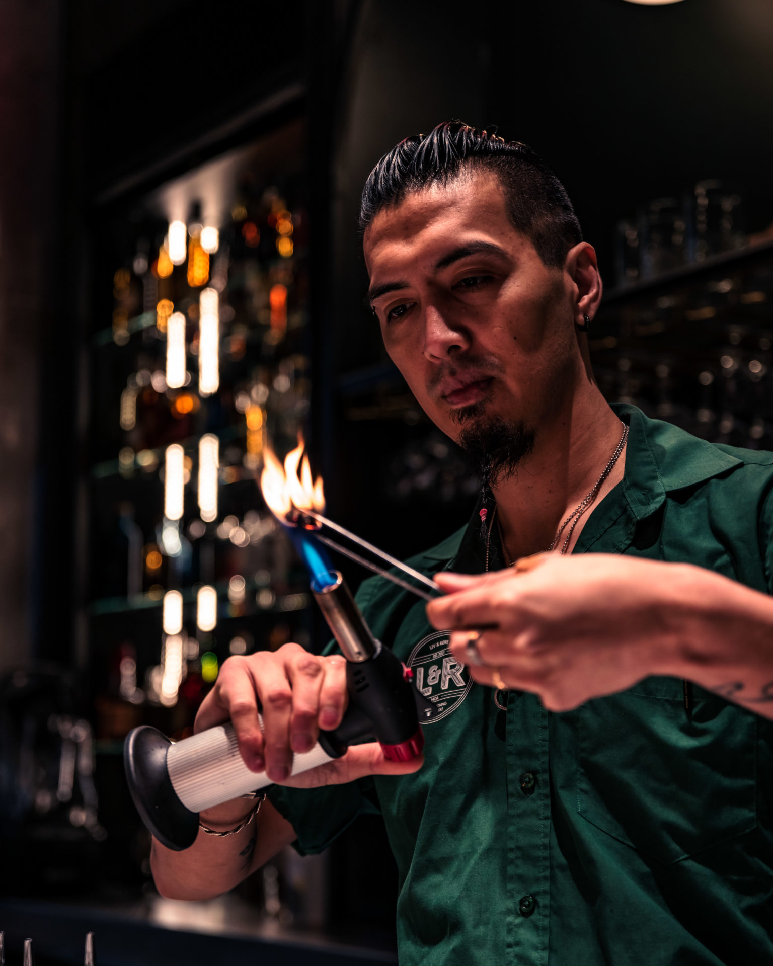 bartender med lighter som lager cocktailer og lager røyk