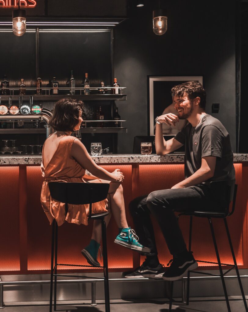 two guests sitting and talking at the bar
