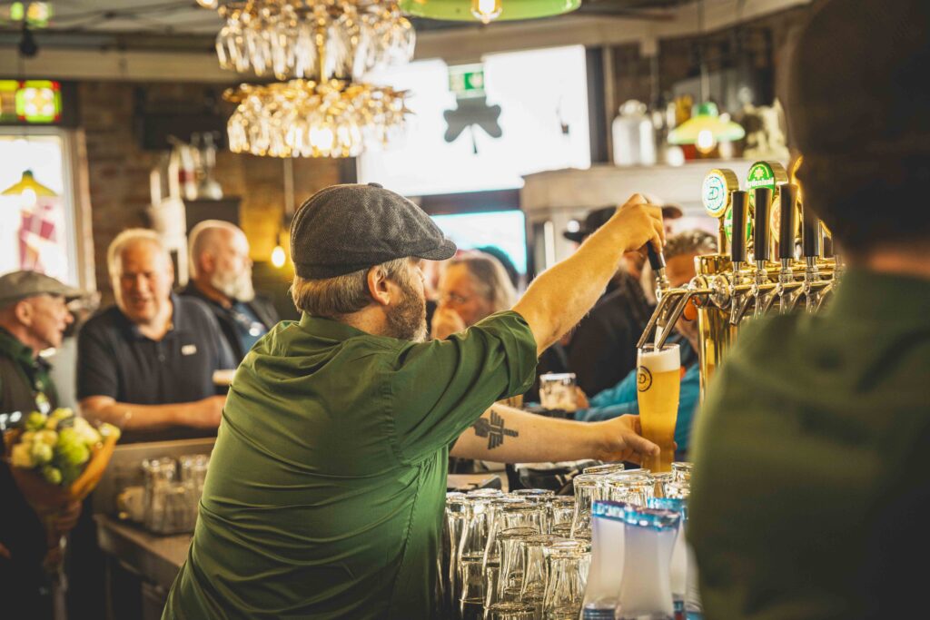 bartender som skjenker øl fra ølkranen