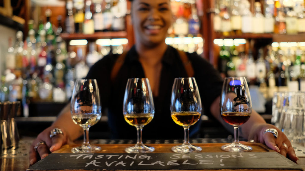 Bilde av bartender som viser frem fire whiskyglass til smaking