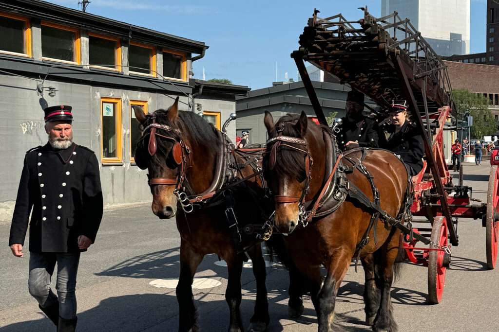 To hester trekker en eldre form for brannvogn gjennom Oslos gater